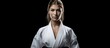 The woman wearing a white Kimono stands on a black background, isolated from the surroundings, showcasing her dedication to fitness and a healthy lifestyle through her intense training and exercise