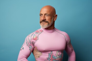 Wall Mural - Portrait of a content man in his 50s showing off a vibrant rash guard against a pastel or soft colors background. AI Generation