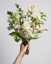 Hand Holding A Bouquet Of White Flowers Isolated On A White Background, A Special Day Gift Celebrate Love Or Anniversary
