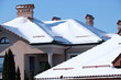© bilanol - Closeup of house roof top covered with snow in cold winter. Tiled covering of building in wintertime weather