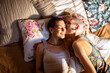 © Marko Geber - Young female couple waking up in the morning in the bedroom