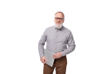 Wall Mural - successful gray-haired mature businessman with a beard and mustache in a shirt and trousers holds a laptop