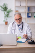 © Elnur - Old male doctor sitting in the clinic