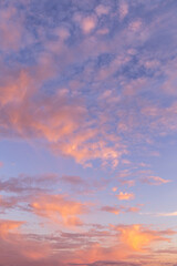 beautiful blue morning sky with many little small fluffy clouds in sunlight and yellow orange sunset