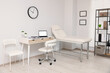 © New Africa - Modern medical office with doctor's workplace and examination table in clinic