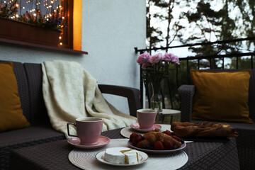 Wall Mural - Rattan table with drink and food on outdoor terrace in evening