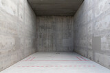 Fototapeta Perspektywa 3d - A concrete racquetball court with red markings on the ground at a public park. The bare cement walls have a grungy look and a splotchy, unfinished texture. The end of the court is cast in shadow.