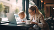 © lelechka - Business woman with kid sitting in cafe and working laptop. Motherhood concept