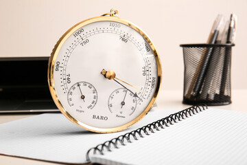 Wall Mural - Aneroid barometer on opened notebook, closeup