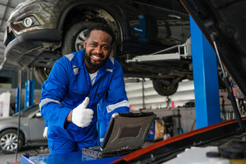 Wall Mural - Auto mechanic in blue uniform are repair and maintenance auto engine is problems at car repair shop.