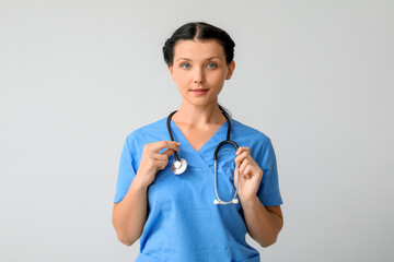 Sticker - Female doctor with stethoscope on light background