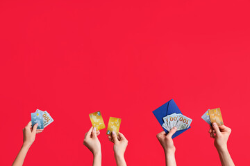 Poster - Female hands with credit cards and money on red background