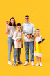 © Pixel-Shot - Happy family with food and cooking utensils on yellow background