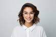 © Mikhail - Portrait of a young pretty smiling woman in glasses, wearing white shirt on a light gray background
