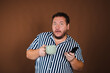 © vladorlov - Early morning and various news. Funny fat man with a mug of coffee.