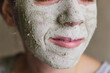The woman applied green clay to her face as part of her regular cosmetic procedures. Clay is a natural cleanser and detoxifier for the skin.