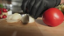 Chef Cutting Onion With Knife On Cutting Board