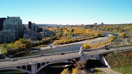 Wall Mural - Prince's Island Park autumn foliage scenery. Aerial view of Downtown City of Calgary Centre St Bridge. Alberta, Canada. 