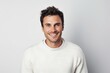 © CogniLens - Portrait of a smiling man in his 30s dressed in a warm wool sweater against a white background. AI Generation