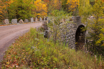 Poster - Gravel Road Over A Stone Arch Bridge In The Woods In Autumn