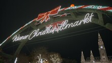 Illuminated entrance sign for the Vienna Christmas market and fair during season. Fun and festive celebrations with traditional food and drinks. Tourists and residents visit at winter time in Austria