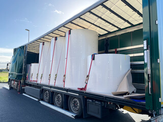 Wall Mural - loading, transporting and unloading large rolls of paper in a semi-trailer. securing cargo with stra