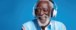 © Michal - Old senior black man or african wearing white headphones. African portrait wide banner on blue background