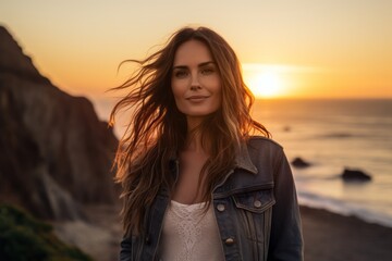 Wall Mural - Portrait of a satisfied woman in her 30s sporting a rugged denim jacket against a vibrant beach sunset background. AI Generation