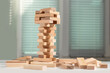 Board game Jenga Tower made of wooden blocks. A tower of unevenly shifted wooden beams.