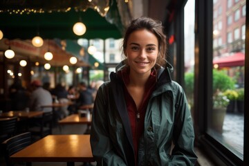 Poster - Portrait of a satisfied woman in her 20s wearing a functional windbreaker against a bustling restaurant background. AI Generation