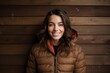 © CogniLens - Portrait of a happy woman in her 20s sporting a quilted insulated jacket against a light wood minimalistic setup. AI Generation