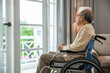 © sorapop - Asian senior man disabled sitting alone in wheelchair looking through window at hospital, lonely elder thoughtful sad old man look outside windows in bedroom at retirement home, feel depressed lonely