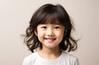 © ckybe - An Asian youngster beaming brightly isolated against a white background.