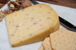 © barmalini - Piece of Dutch Gouda cheese made from cow milk with added walnuts close up
