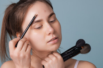 a girl with acne sticks an acne patch on her cheek. using mini plaster on makeup