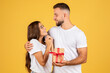 © Prostock-studio - Smiling young european man gives box present to surprise lady