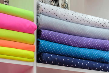 Poster - Shelf with a wide selection of colorful fabrics. Colorful ribbons on the shelf in the store. Textile industry