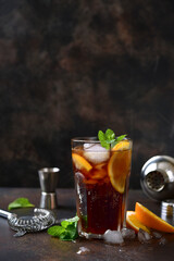 Wall Mural - Cold summer soda cocktail with cola, dark rum and orange in a tall glass.