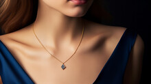 Delicate Golden Necklace With A Sapphire Pendant Worn By A Model Closeup Isolated On Black Background
