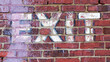 The word EXIT painted on a grungy brick wall background