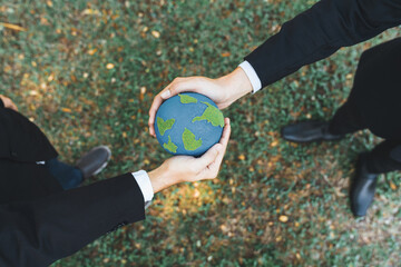 Earth day concept, top view businessman giving Earth globe as CSR corporate social responsible principle to promote environmental awareness and embrace ESG for greener and sustainable future. Gyre