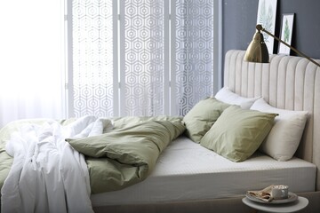 Sticker - Comfortable bed with new pistachio linens in modern room interior