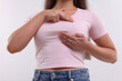 © New Africa - Woman doing breast self-examination on white background, closeup