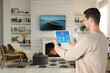 © New Africa - Man using smart home control system via application on tablet indoors
