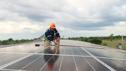 Wall Mural - Engineer electrician asia check the installation of solar panels on metal roofs in industrial plants. Use a tape measure to measure the length of the solar panels and record the data on a tablet.