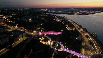 Wall Mural - View from drone of Chkalovskaya Staircase and St George Tower of Nizhny Novgorod Kremlin at night with illumination on background with modern cityscape on banks of Volga river in summer, Russia