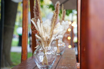 Wall Mural - A vase with dried flowers on a wooden shelf.