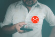 Unhappy man customer with choosing sad emotion face via smartphone. Bad review and service dislike poor quality, low rating, the order has been cancelled. Customer experience dissatisfied.