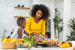 © Art_Photo - Portrait of enjoy happy love african american family mother and african little boy son child having fun help cooking food healthy eat together with fresh vegetable salad and ingredient in kitchen