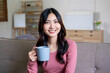 © MIND AND I - Woman spend time at home seated on sofa